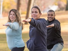 Three people doing yoga in an outdoor setting